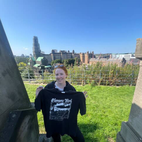 Person holding a hoodie with a cityscape in the background